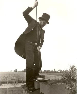 A Doctor Flue chimney sweep at work on a rooftop